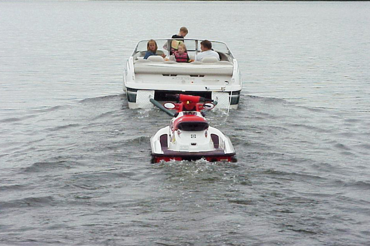Towing a jet ski behind a boat at slow speed is typically safe